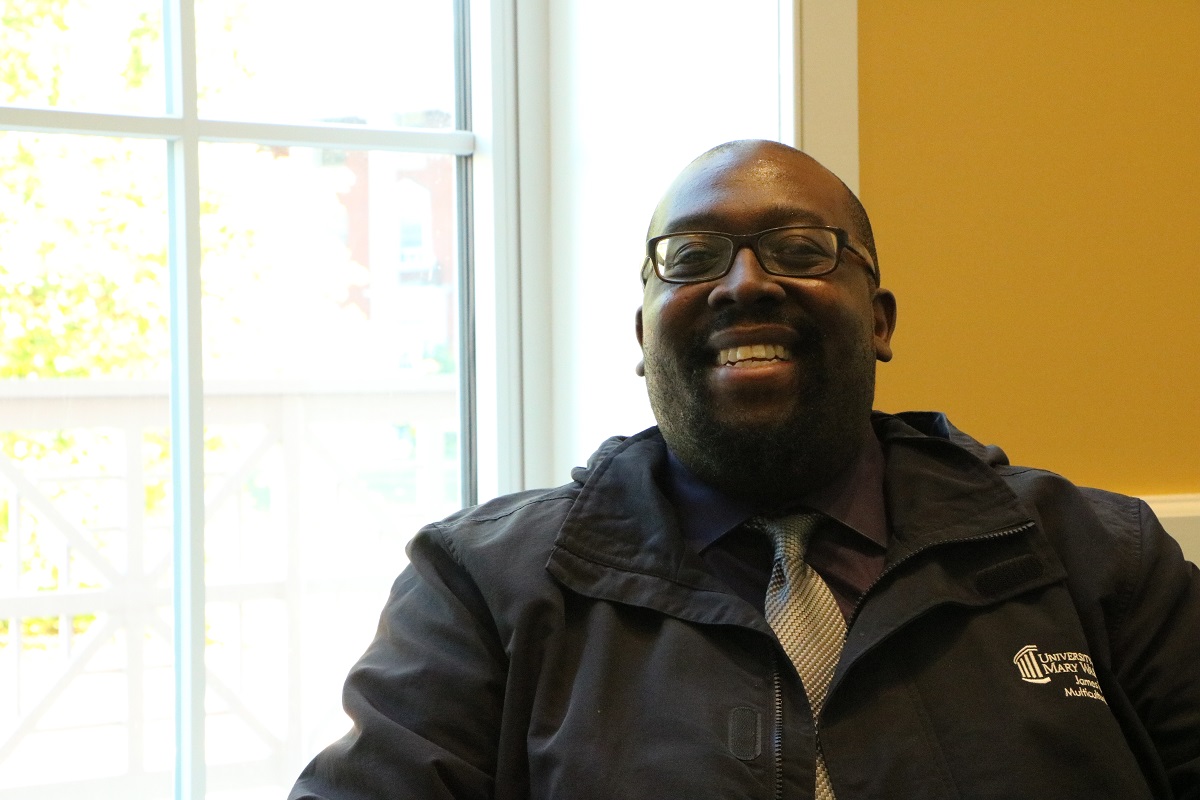 man in a tie smiling in front of a window