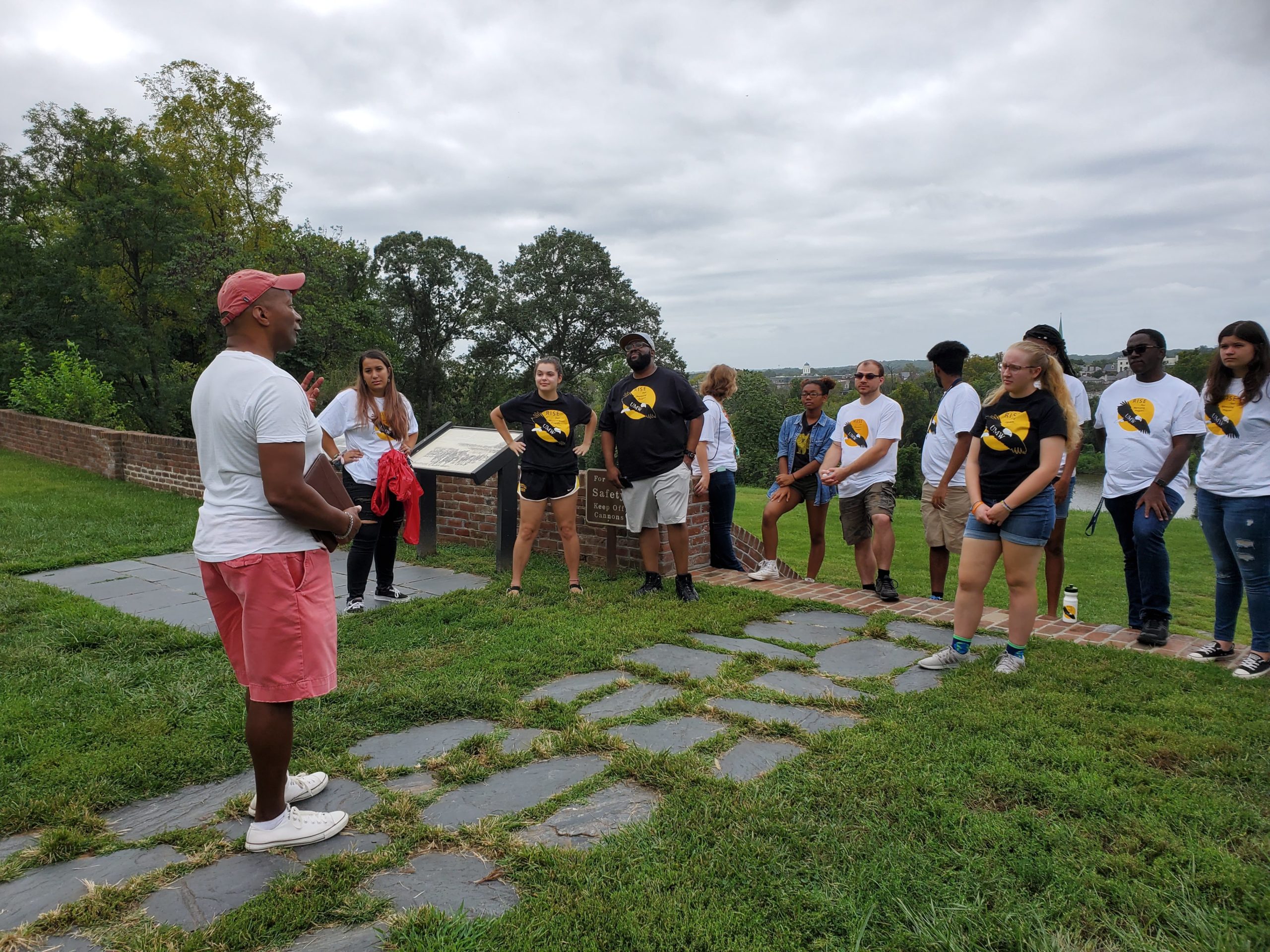 Outside the Chatham Manor, RISE students listen intently to Dean Rucker discuss Fredericksburg history