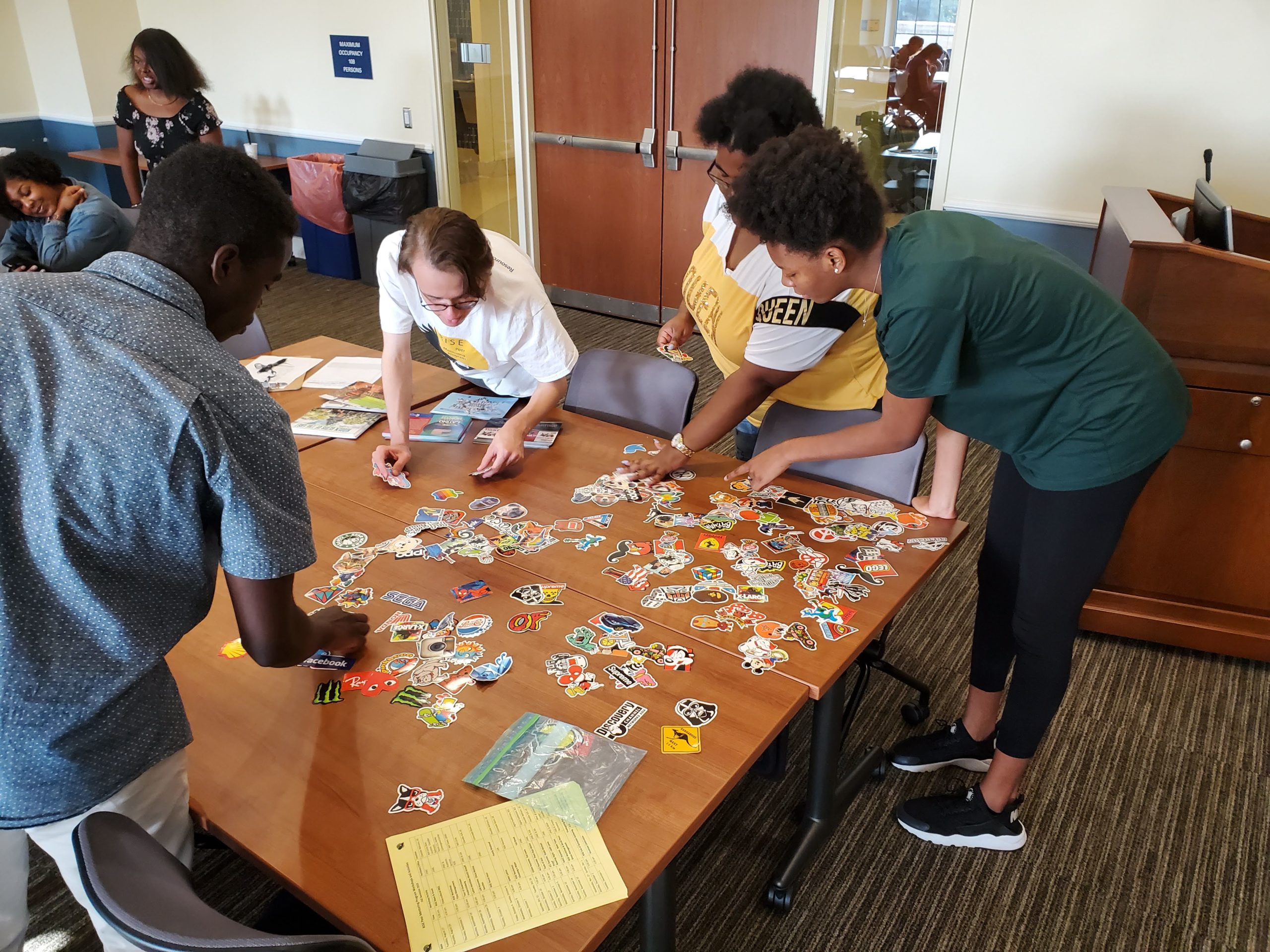 A group of RISE students choosing their favorite stickers from a collection